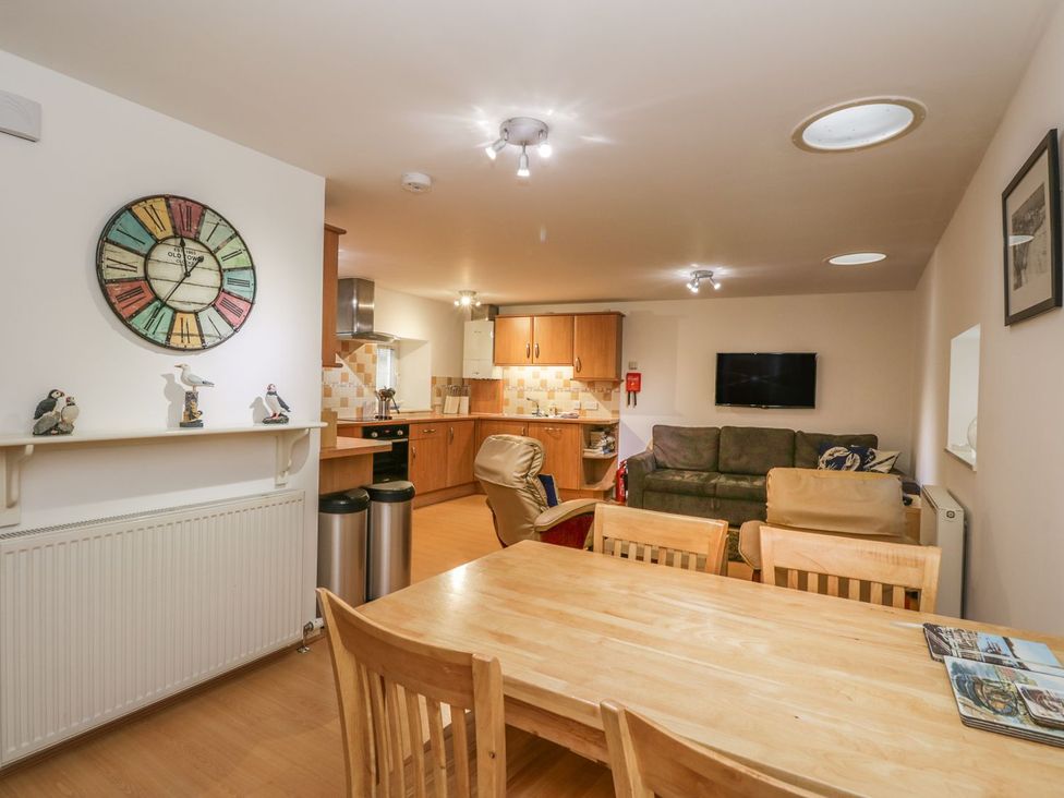 An open plan living area with a dining table and kitchen features at Hay Loft in Anstruther