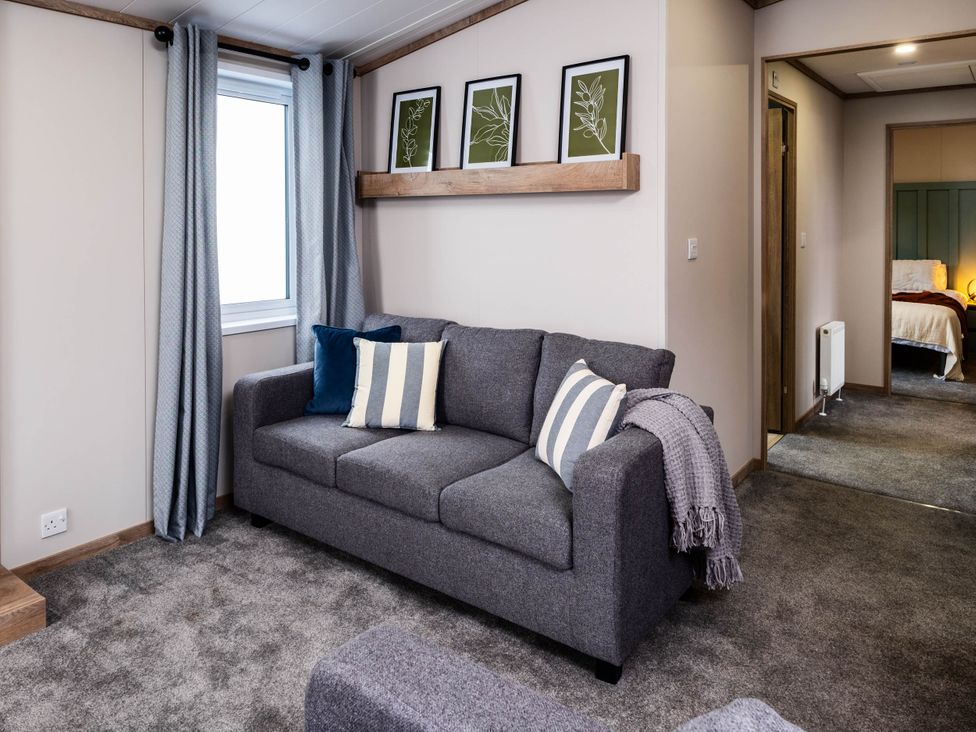 A living room with a sofa and wall art at No 9 Blakemere Lodge Escape in Northwich