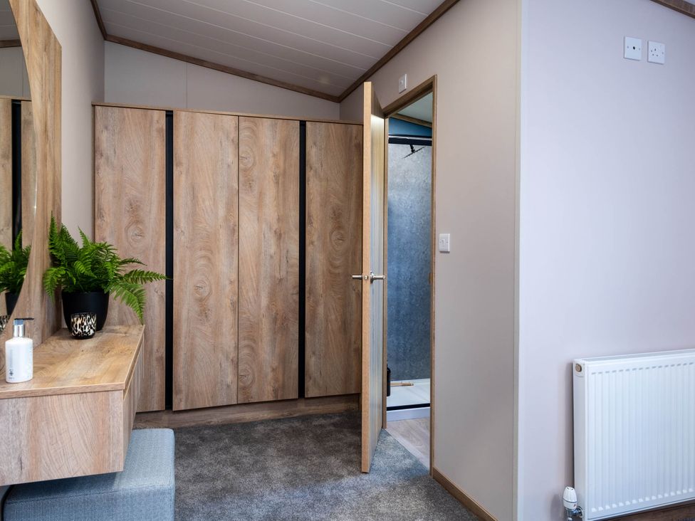 An entrance area with a wardrobe and mirror at No 9 Blakemere Lodge Escape Northwich