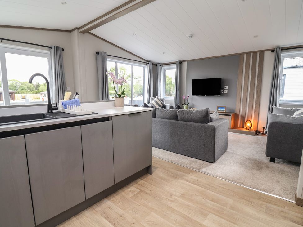 A living room with a sofa and television at Cedar Lodge 2 Bedrooms with hot tub in Delamere