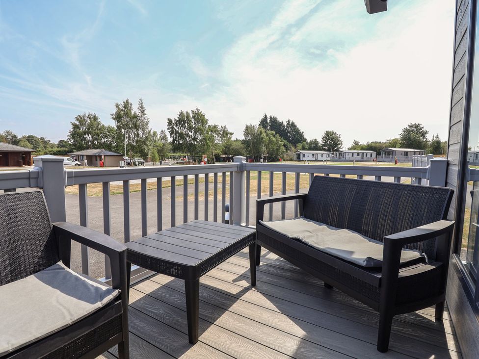 An outdoor seating area with furniture at Cedar Lodge 2 Bedrooms with hot tub in Delamere