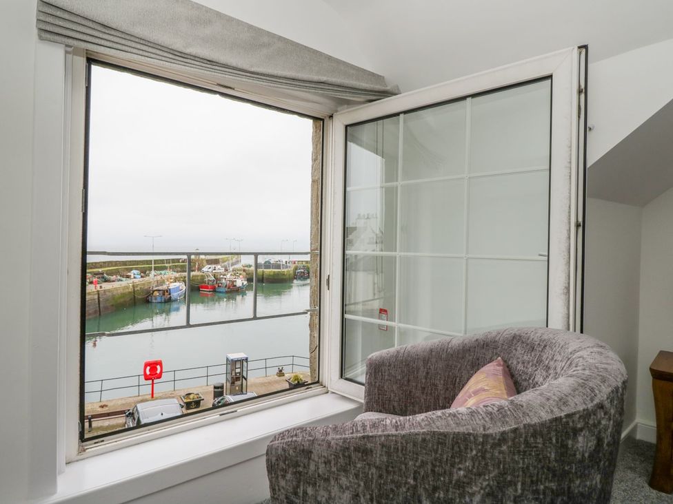 A living room with a view of the harbor at Maimie’s Harbourview in Anstruther