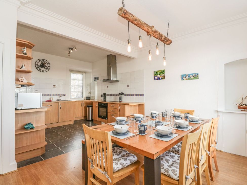A dining room with a table set for meals at Maimie’s Harbourview in Anstruther