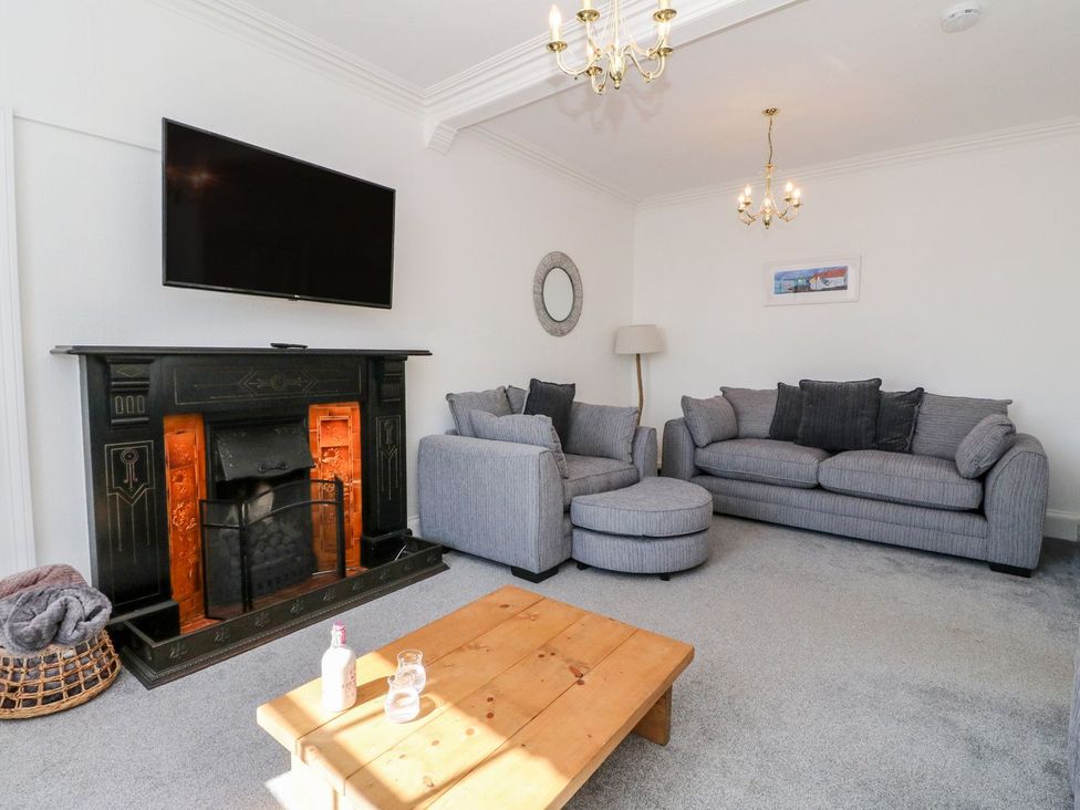 A living room with a fireplace and sofa at Maimie’s Harbourview Anstruther