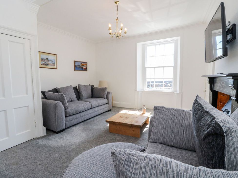 A living room with a sofa and coffee table at Maimie’s Harbourview Anstruther