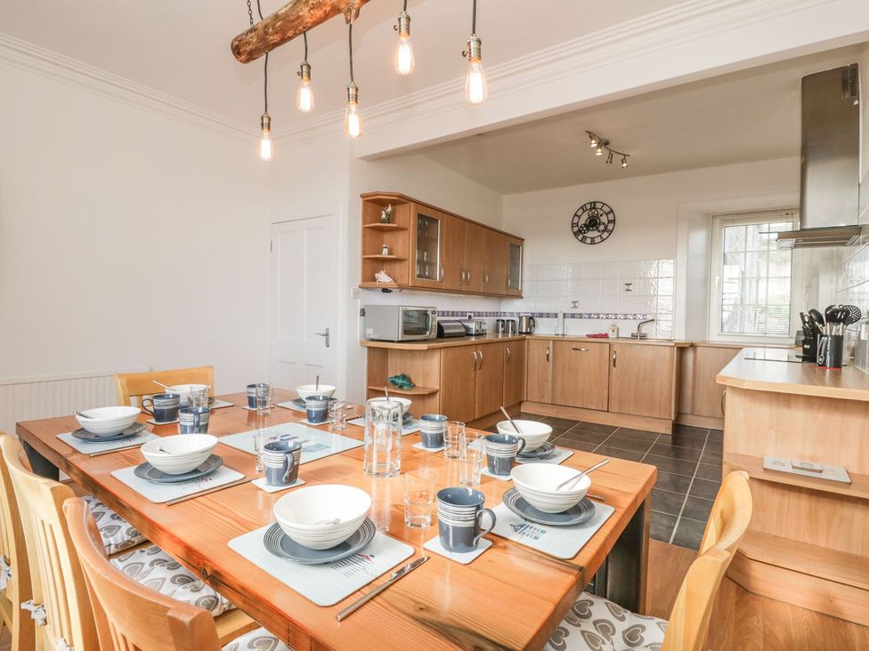 A kitchen with a dining table set for a meal at Maimie’s Harbourview in Anstruther