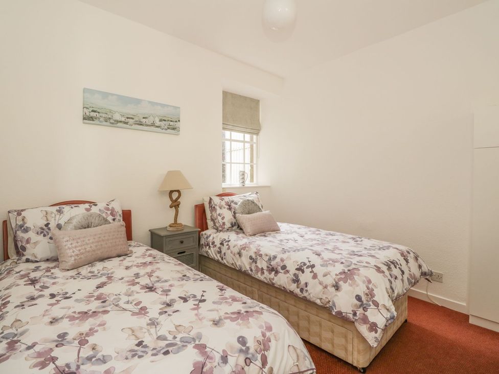 A bedroom with two beds and a bedside table at Maimie’s Harbourview in Anstruther