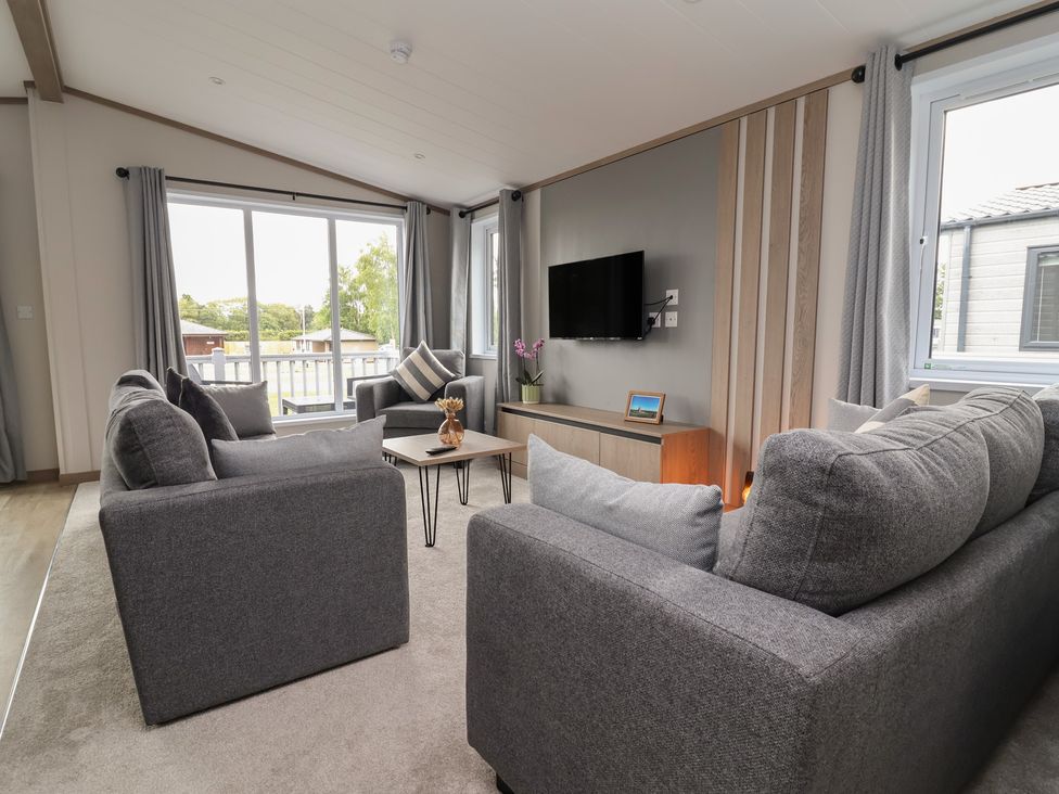 A living room with a sofa and television at Cedar Lodge 2 Bedrooms Delamere