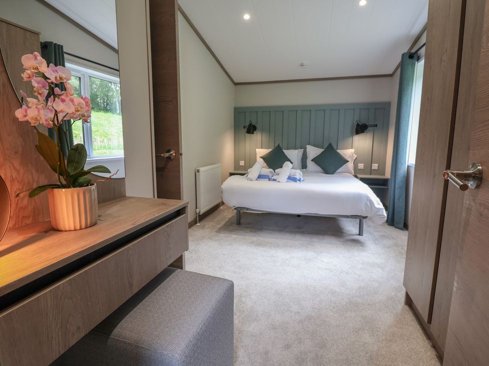 A bedroom with a bed and nightstands at Cedar Lodge 2 Bedrooms in Delamere