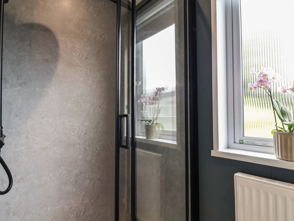 A bathroom with a shower and window at Cedar Lodge 2 Bedrooms Delamere