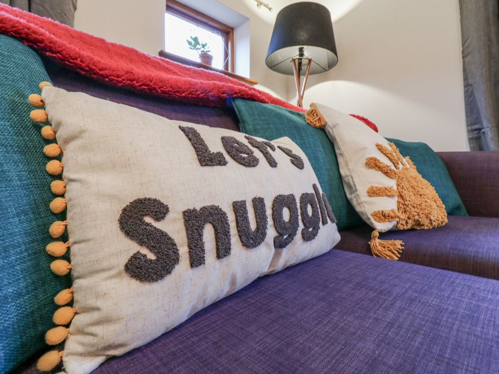 A living room with a couch and decorative pillows at The Pantiles in Banham