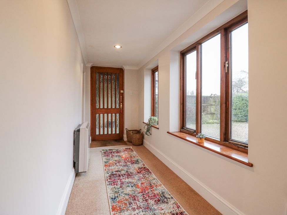 A hallway with windows and a door at The Pantiles in Banham