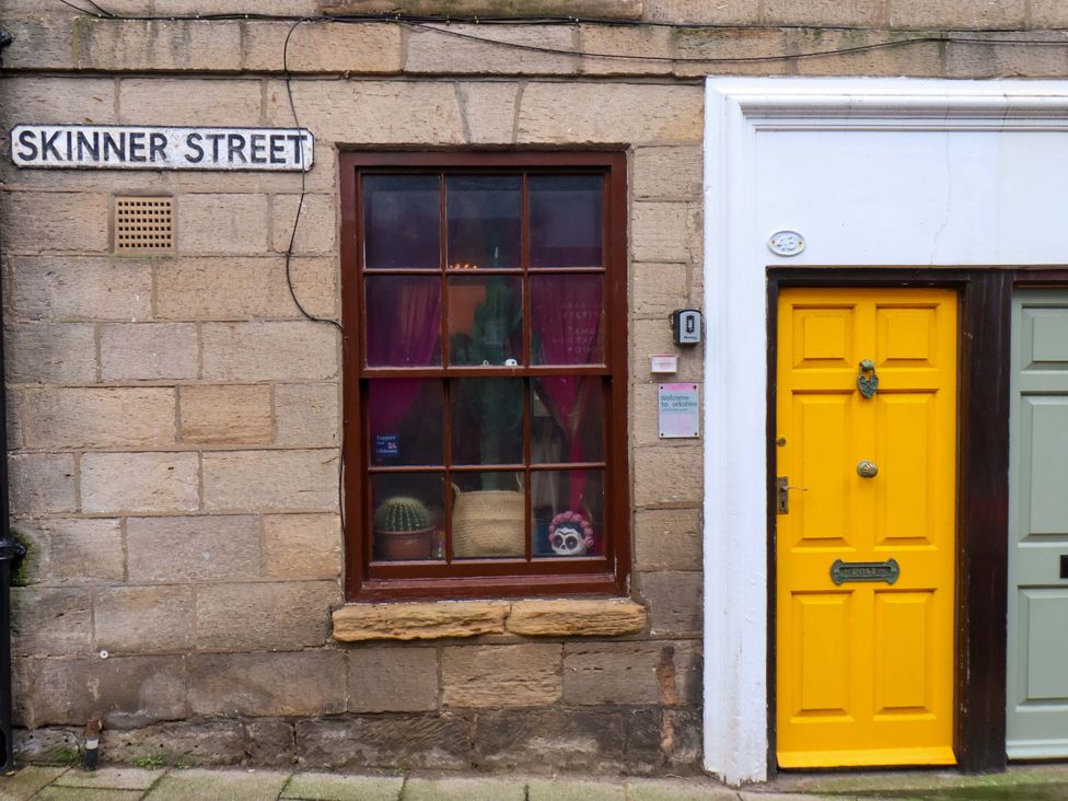 A building facade with a window and yellow door at Frida's Cottage in Whitby