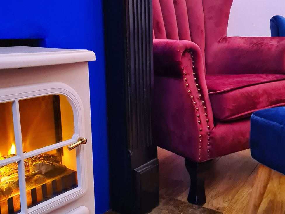 A living room with an armchair and fireplace at Frida's Cottage in Whitby
