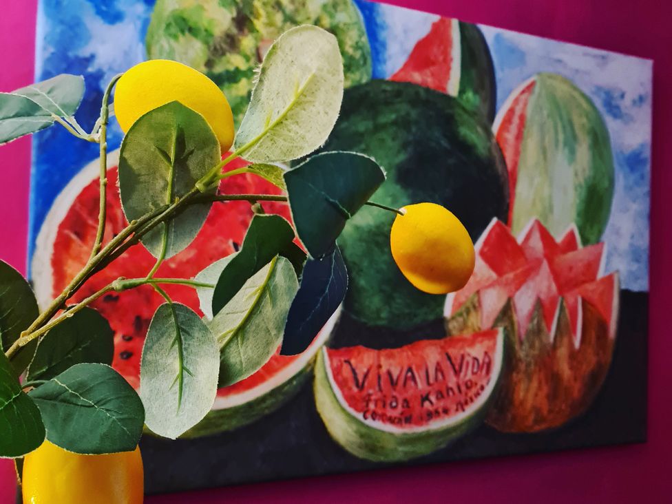 A branch with leaves and a lemon near a painting of fruits at Frida's Cottage in Whitby