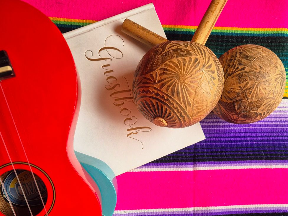 A ukulele and maracas on a decorative cloth at Frida's Cottage in Whitby