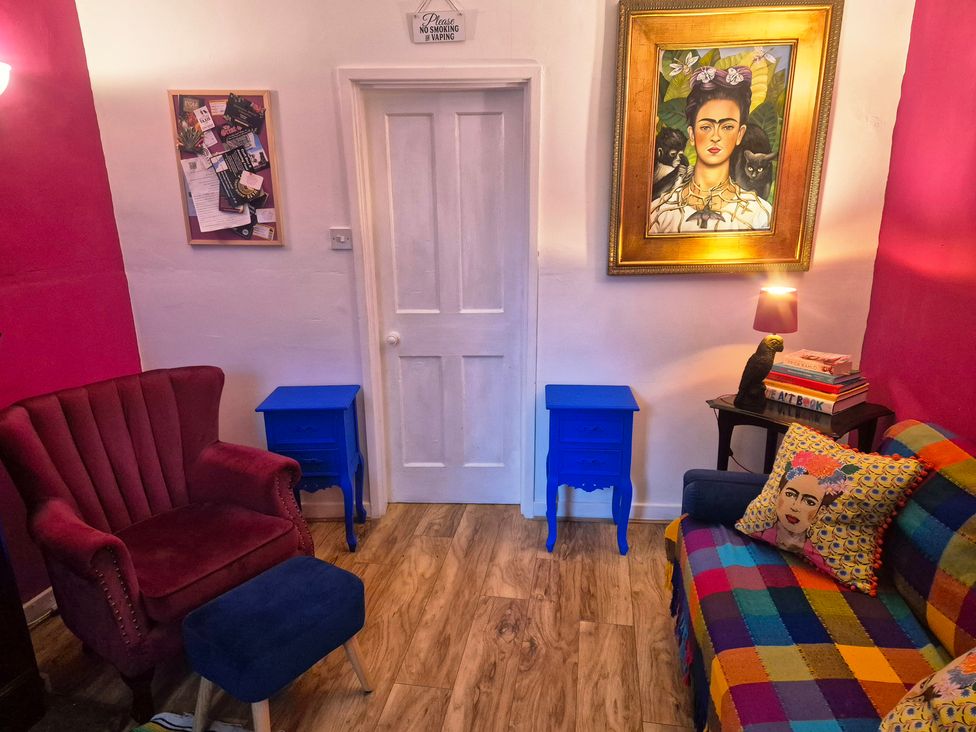 A living room with colorful furniture and artwork at Frida's Cottage in Whitby