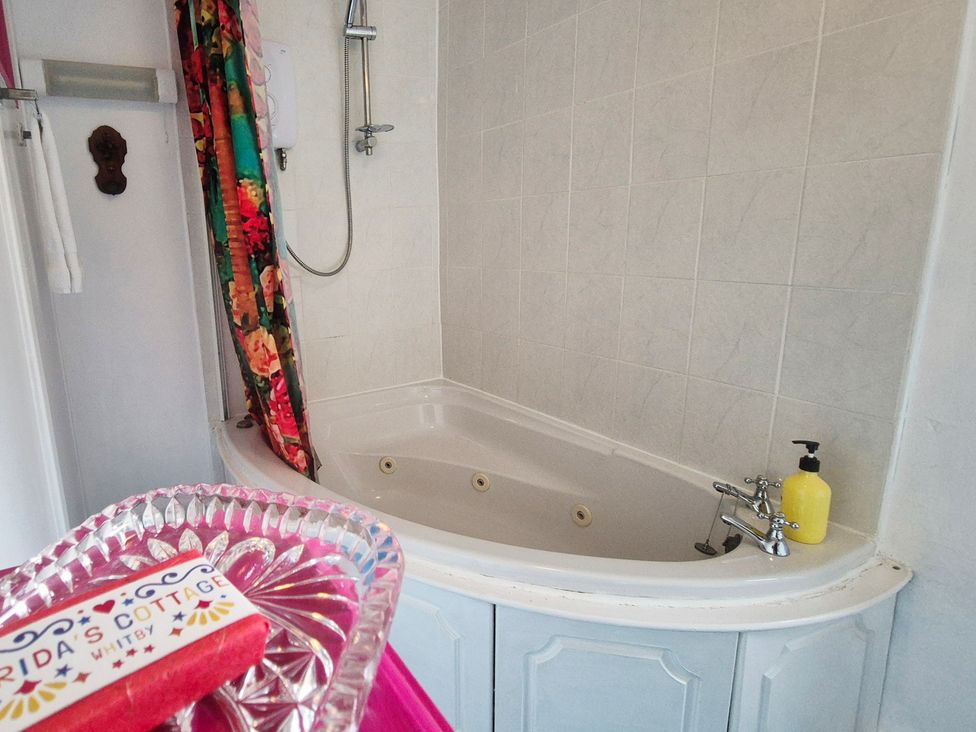 A bathroom with a bathtub and shower at Frida's Cottage in Whitby