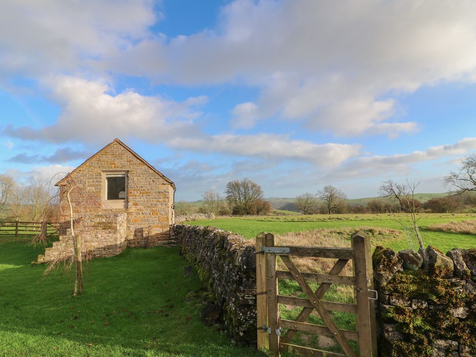 A stone building with a gate and stone wall at Little Barn in Leek