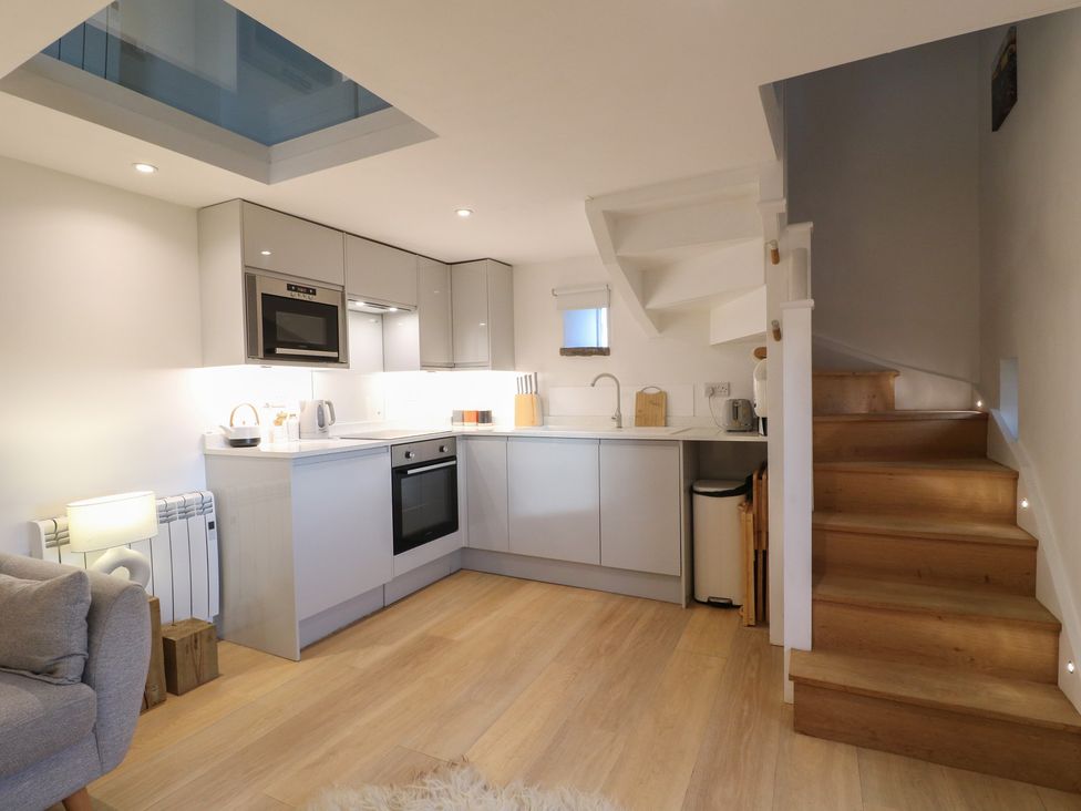 A kitchen with appliances and a staircase at Little Barn in Leek