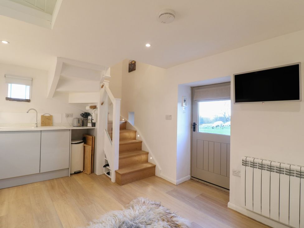 A kitchen with a staircase and door at Little Barn in Leek
