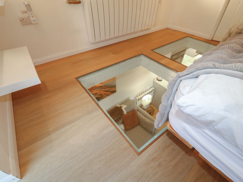 A bedroom with a glass panel in the floor at Little Barn in Leek