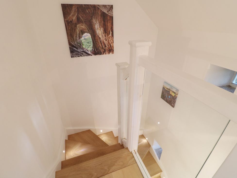 A staircase with wooden steps and wall art at Little Barn in Leek