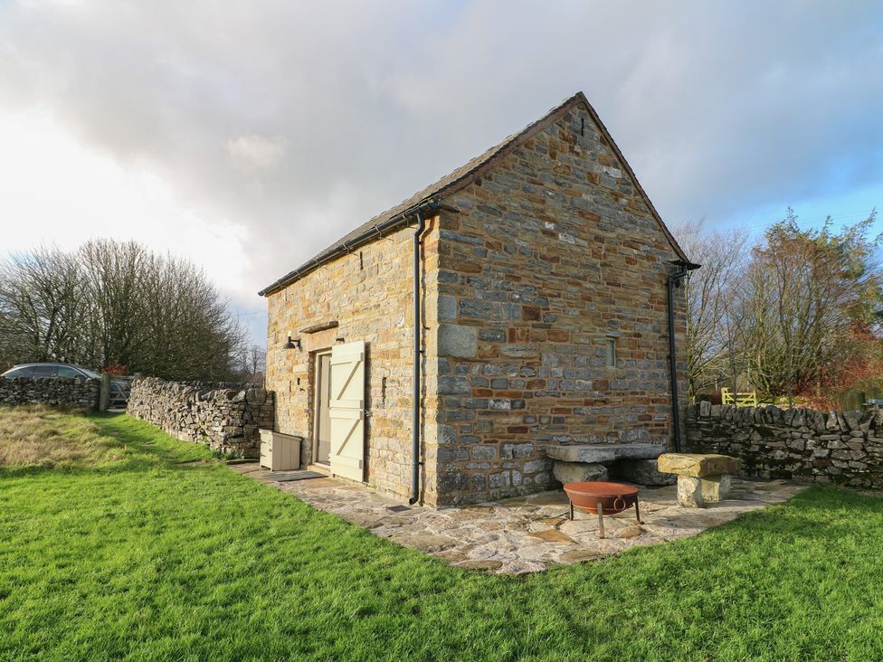 A stone building with a door and window in an outdoor area at Little Barn Leek
