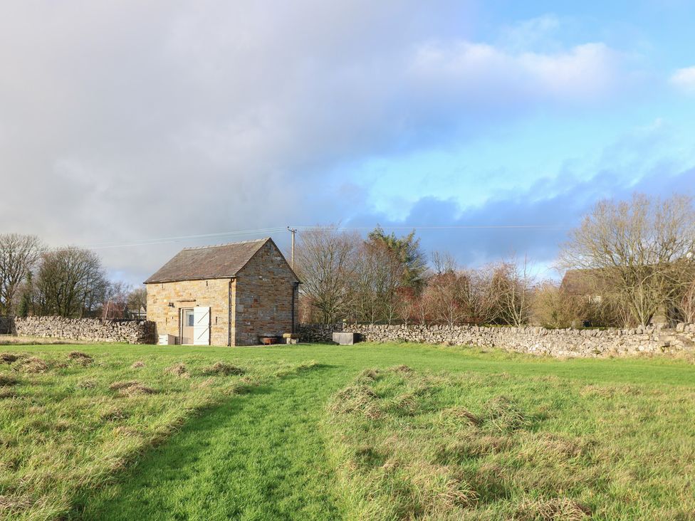 A stone building in a grass field at Little Barn Leek