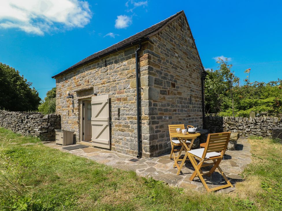 A stone building with a table and chairs at Little Barn in Grindon