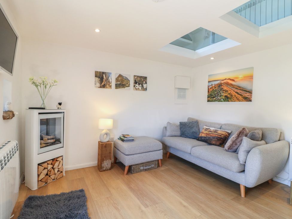 A living room with a sofa and fireplace at Little Barn in Grindon