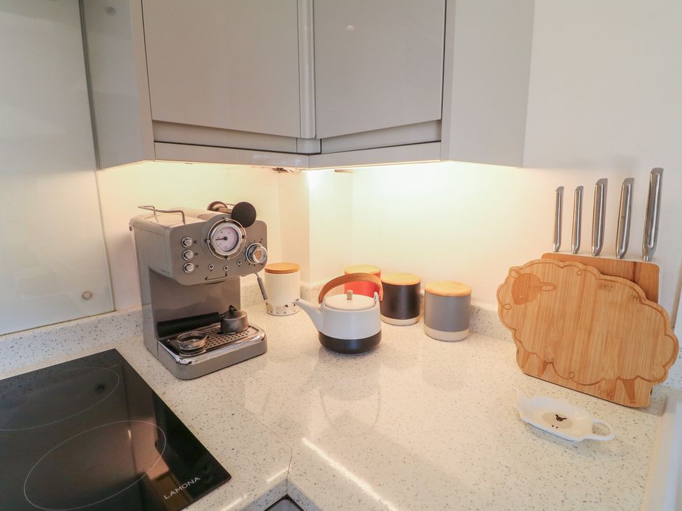 A kitchen with a coffee machine and cutting board at Little Barn in Grindon