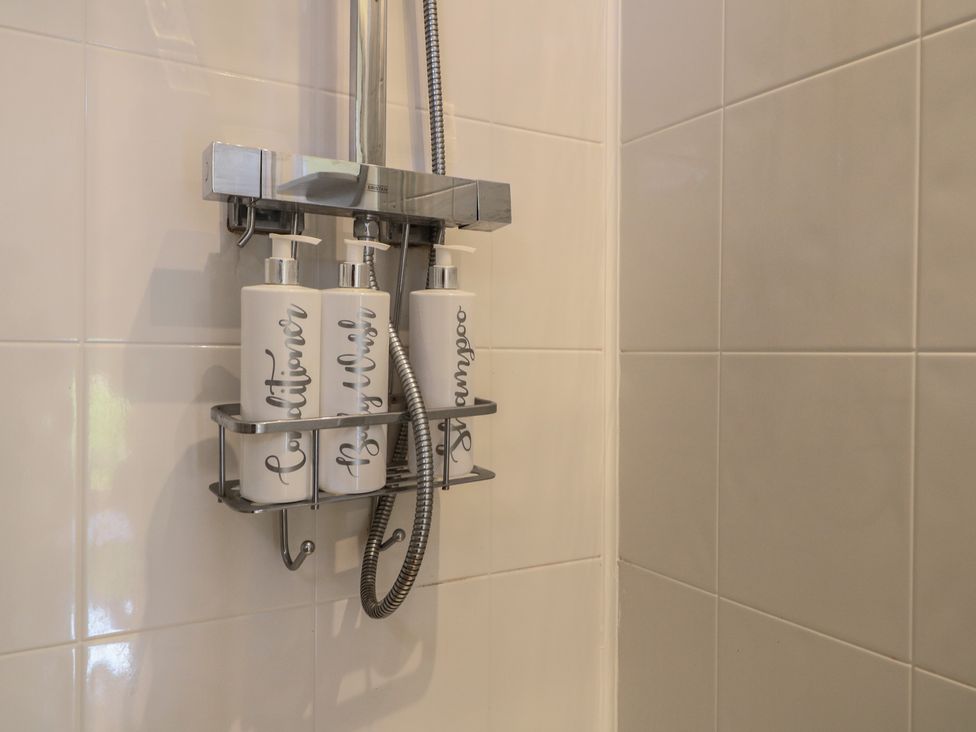 A shower with shampoo and conditioner bottles at Little Barn in Grindon