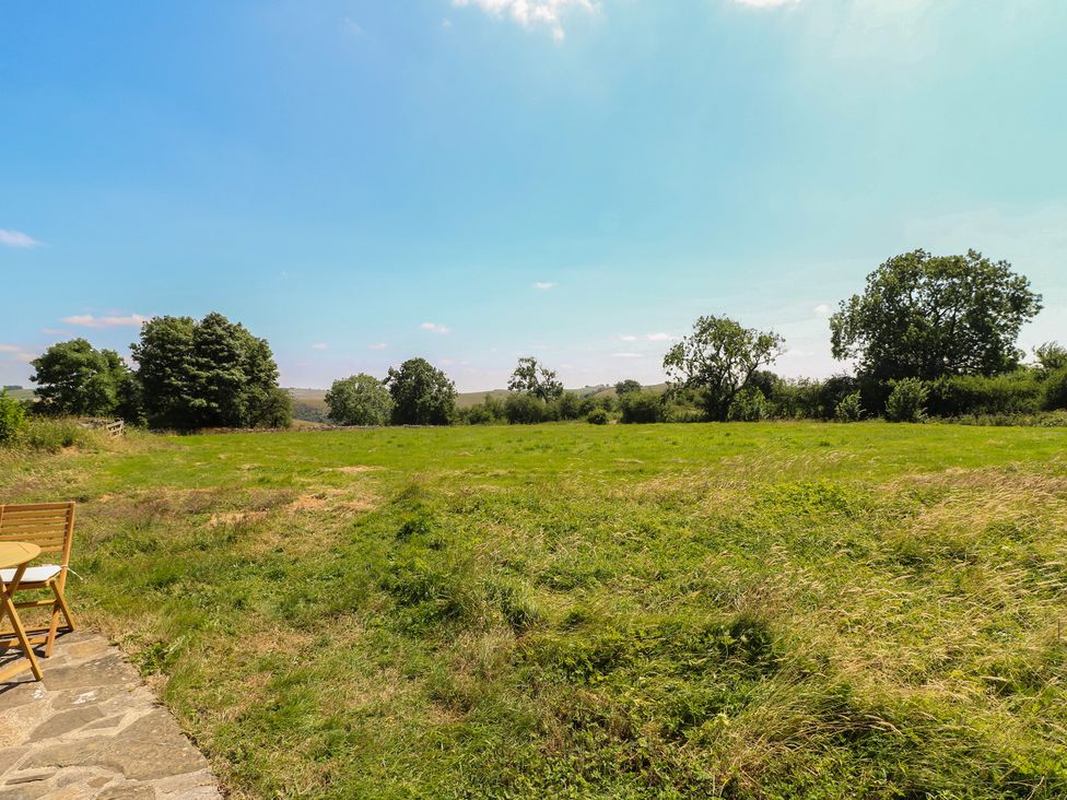 A garden area with grass and trees at Little Barn in Grindon