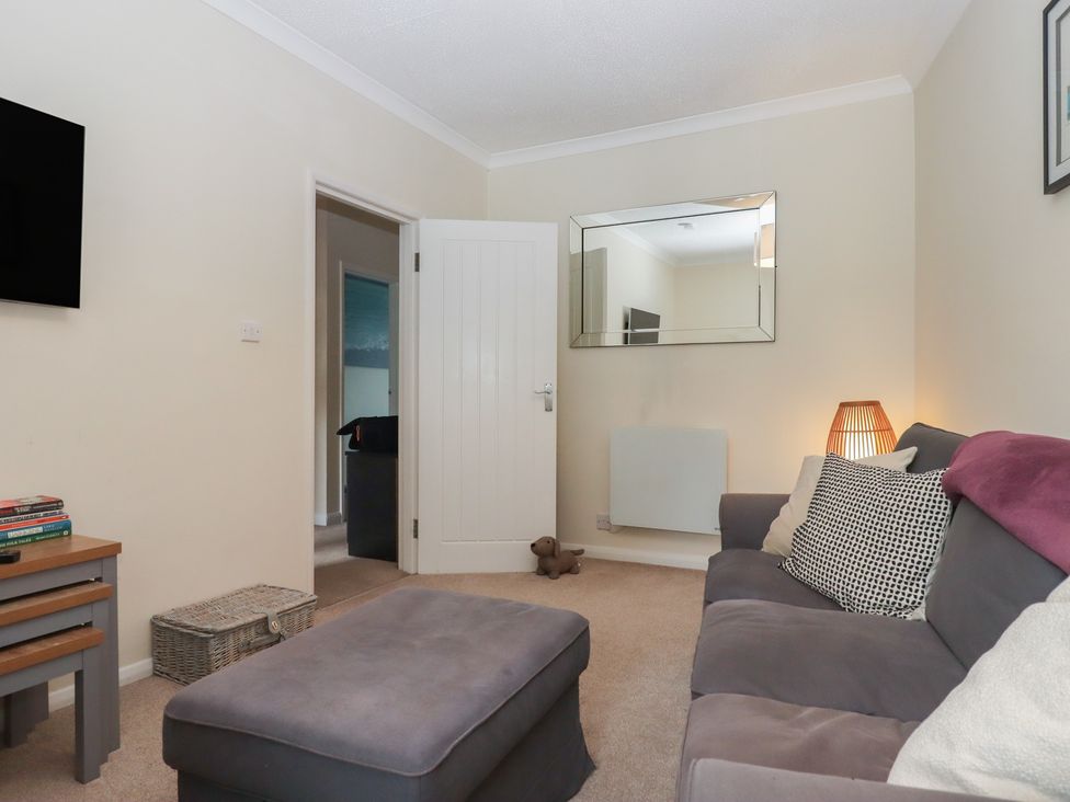 A living room with a sofa and television at Petitor Mews