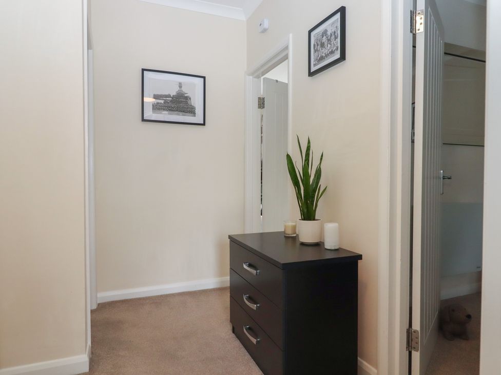 A hallway with a drawer unit and pictures at Petitor Mews 