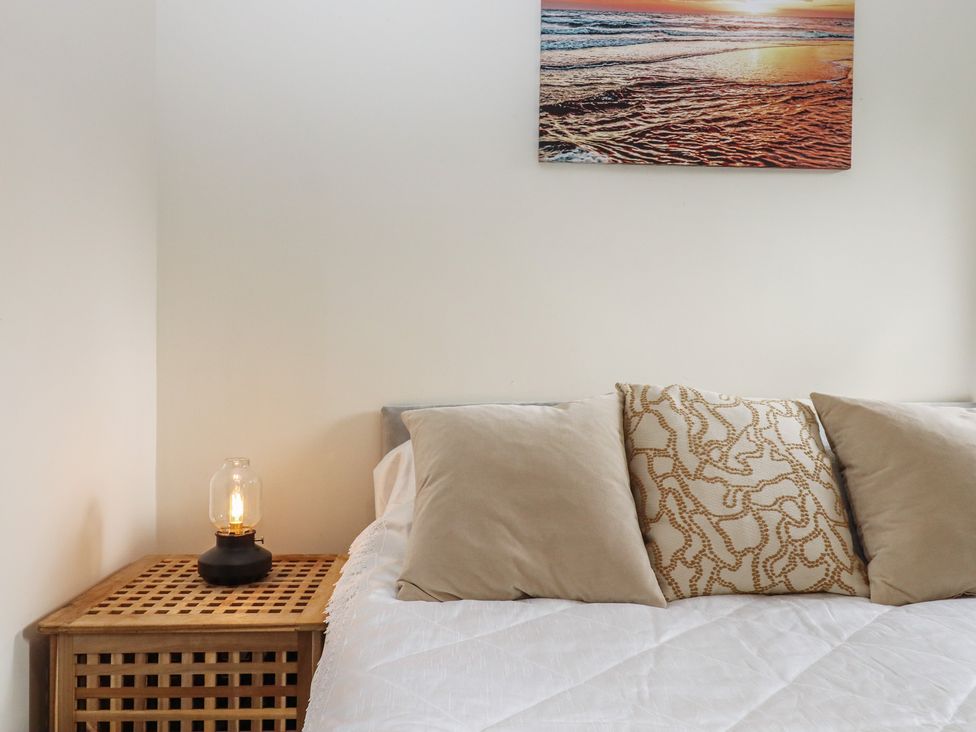 A bedroom with a bed and a side table at Petitor Mews