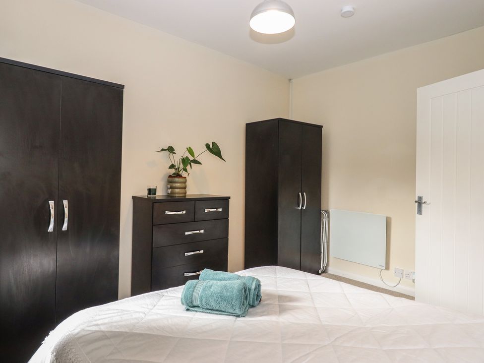 A bedroom with a bed, cabinets and a chest of drawers at Petitor Mews in 