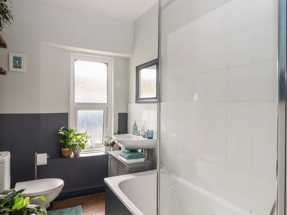 A bathroom featuring a toilet, sink, bathtub, and plants at Petitor Mews