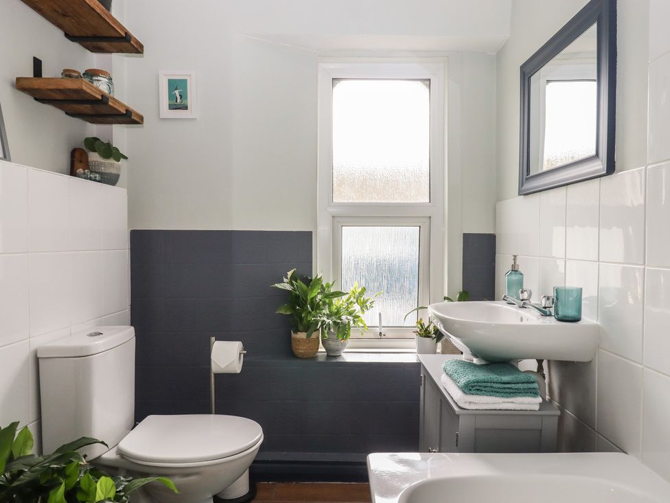 A bathroom with a toilet, sink, and plants at Petitor Mews