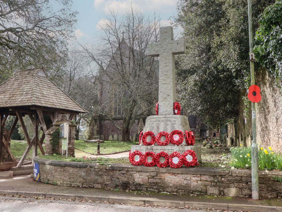 A war memorial with wreaths and trees at Petitor Mews