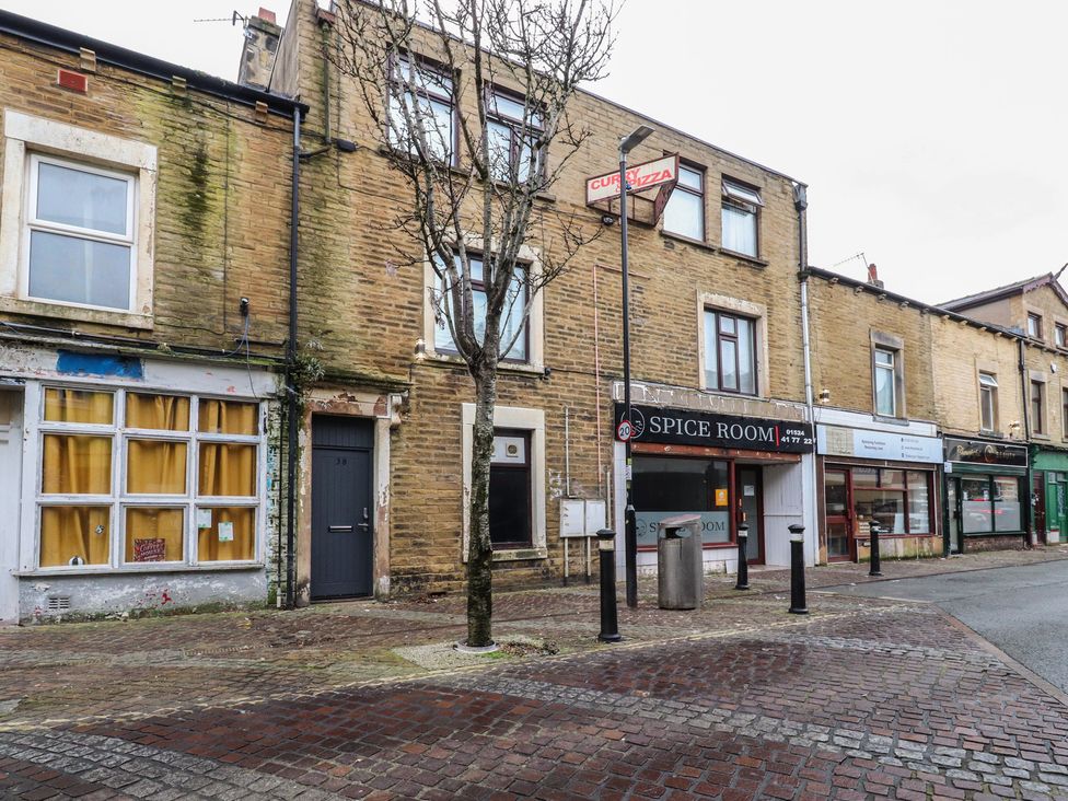 A street view with storefronts and trees at 38a Yorkshire Street