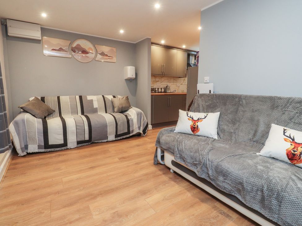 A living room with sofas and kitchen cabinets at 38a Yorkshire Street