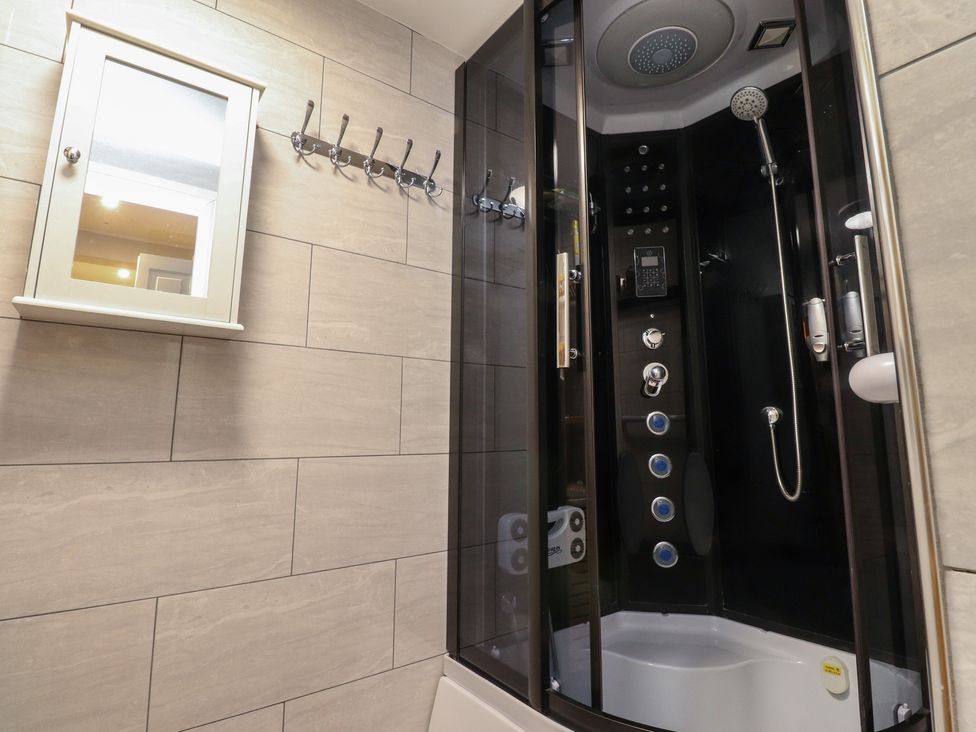 A bathroom featuring a shower and mirror at 38a Yorkshire Street