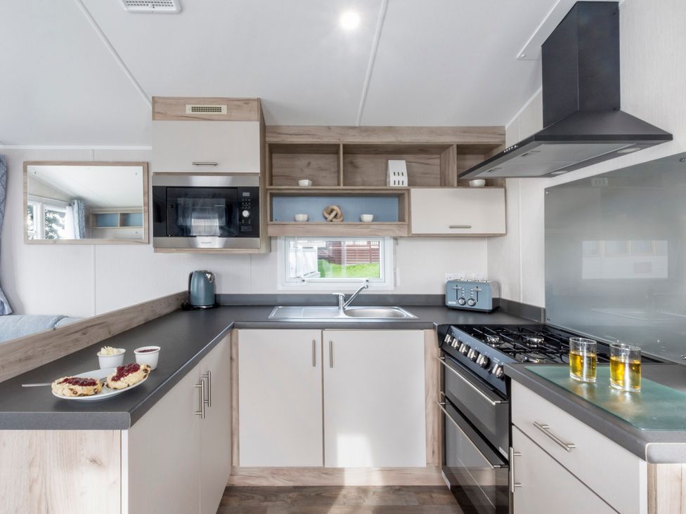 A kitchen with a sink and cooking range at Caravan C31 at Landscove Holiday Park Brixham