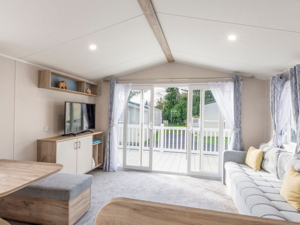 A living room with a television and a sofa at Caravan C31 at Landscove Holiday Park Brixham