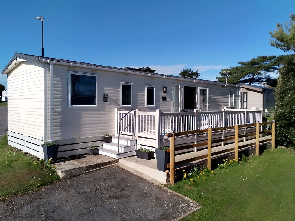 A mobile home with a porch and steps at 48 Woodland View in Lymington