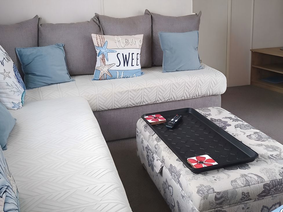 A living room with a sofa and coffee table at 48 Woodland View in Lymington