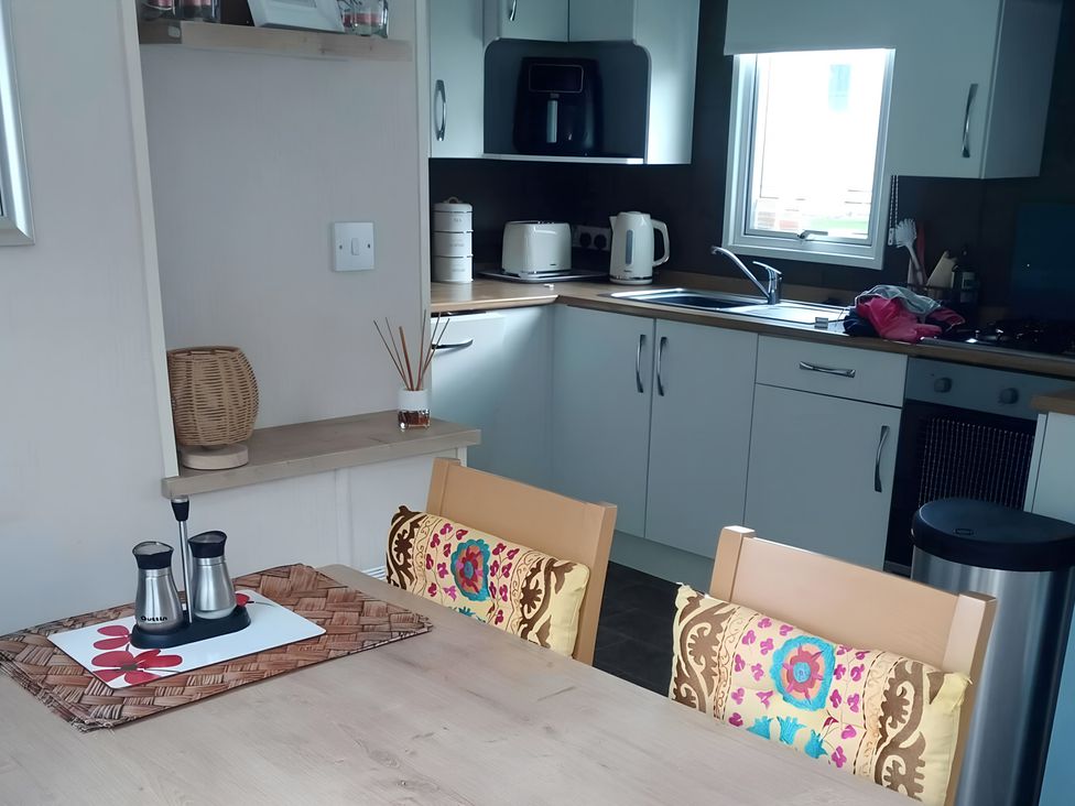 A kitchen with a table and chairs at 48 Woodland View in Lymington