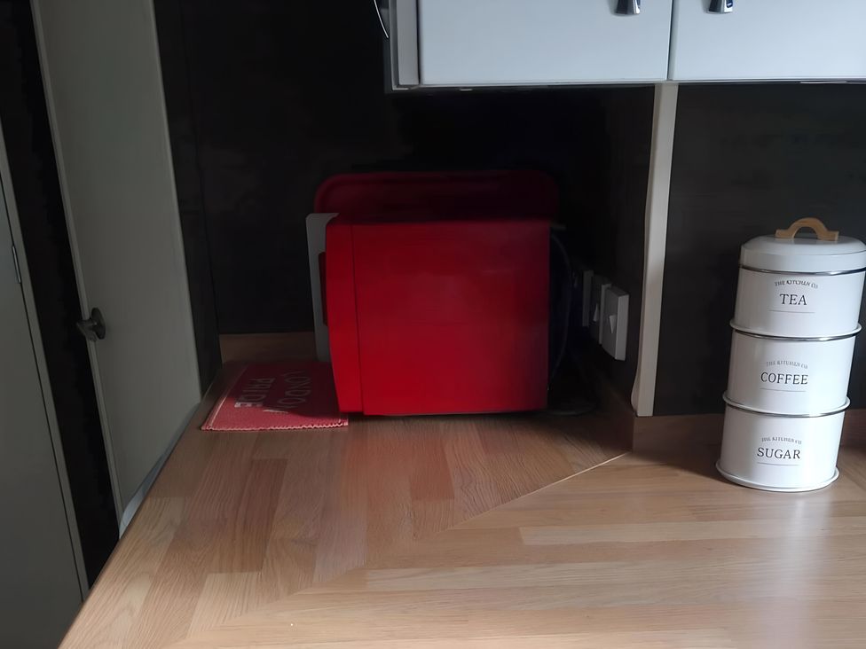 A kitchen with a microwave and canisters at 48 Woodland View Lymington